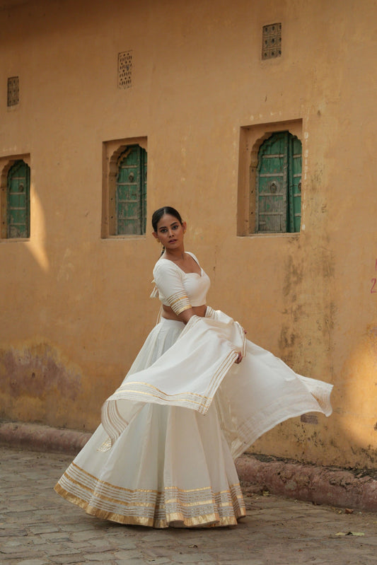 White cotton lehenga set with intricate gota and lappa work. 