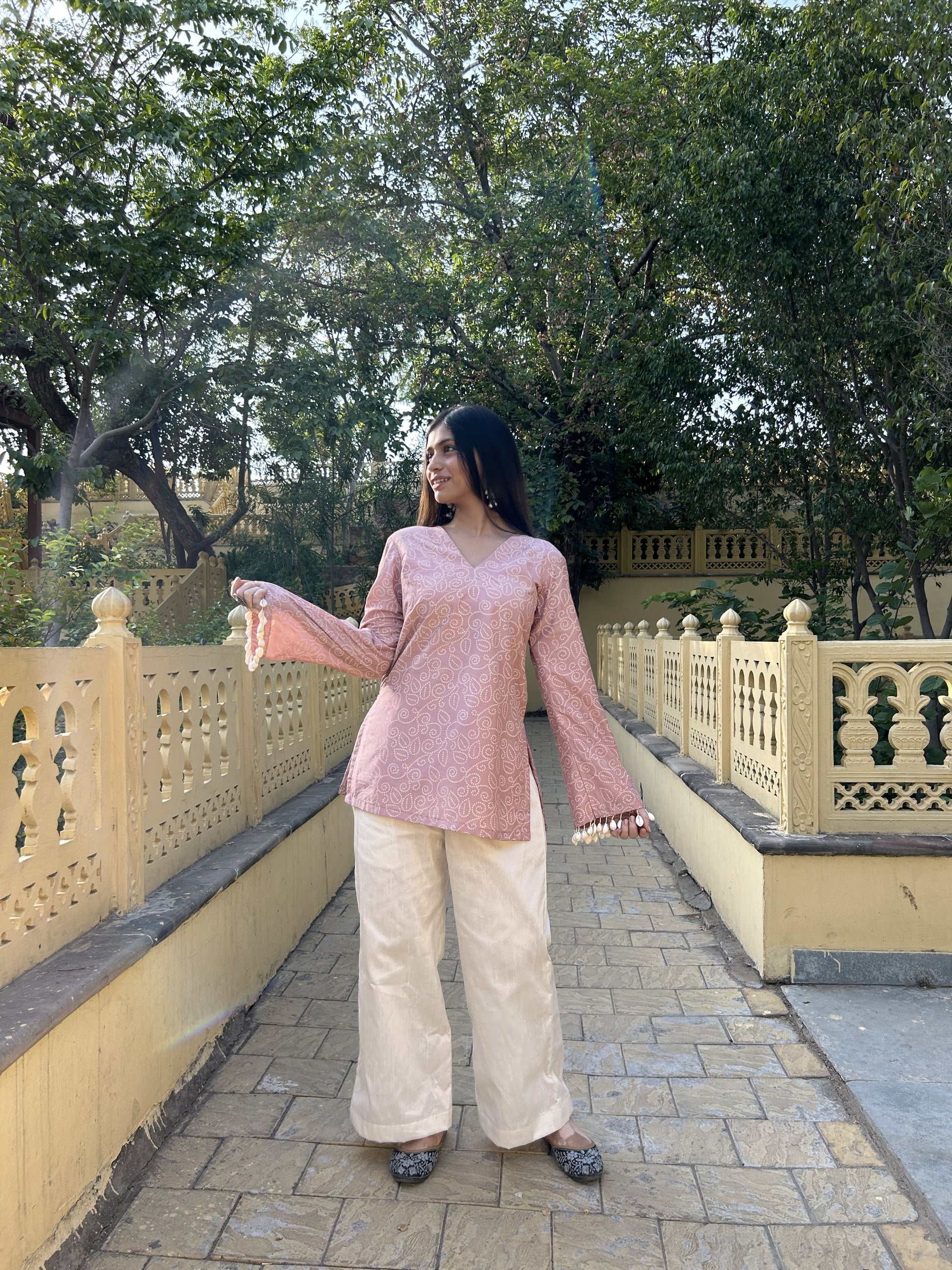 Soft pink printed short kurta with pearl and shell sleeve detailing.