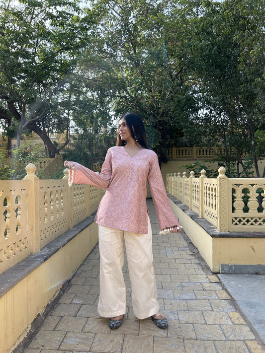 Soft pink printed short kurta with pearl and shell sleeve detailing.